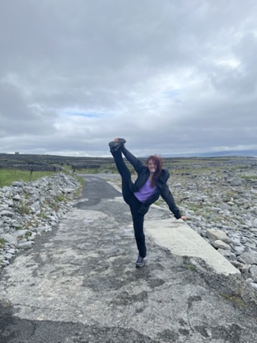 Bella doing a high kick on a path in Ireland