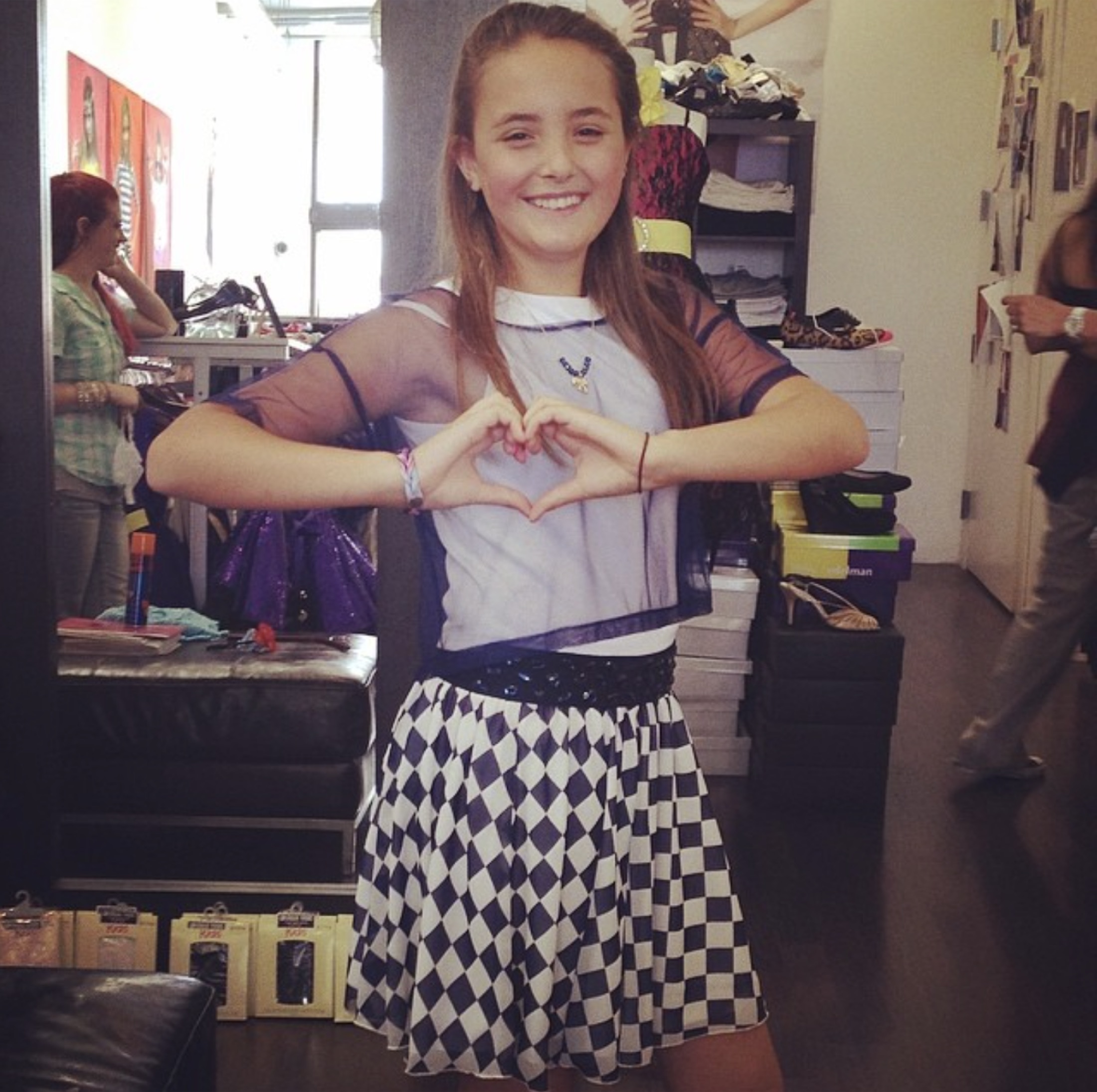 Bella as a kid, making a heart with her hands